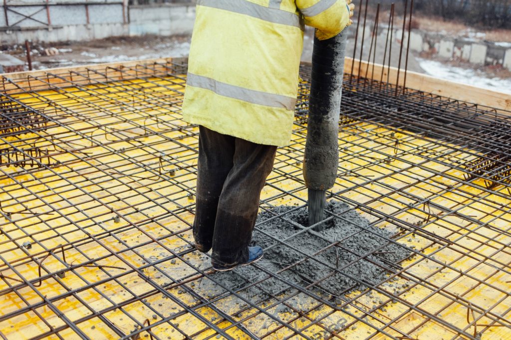 Male builder pours concrete with a pump